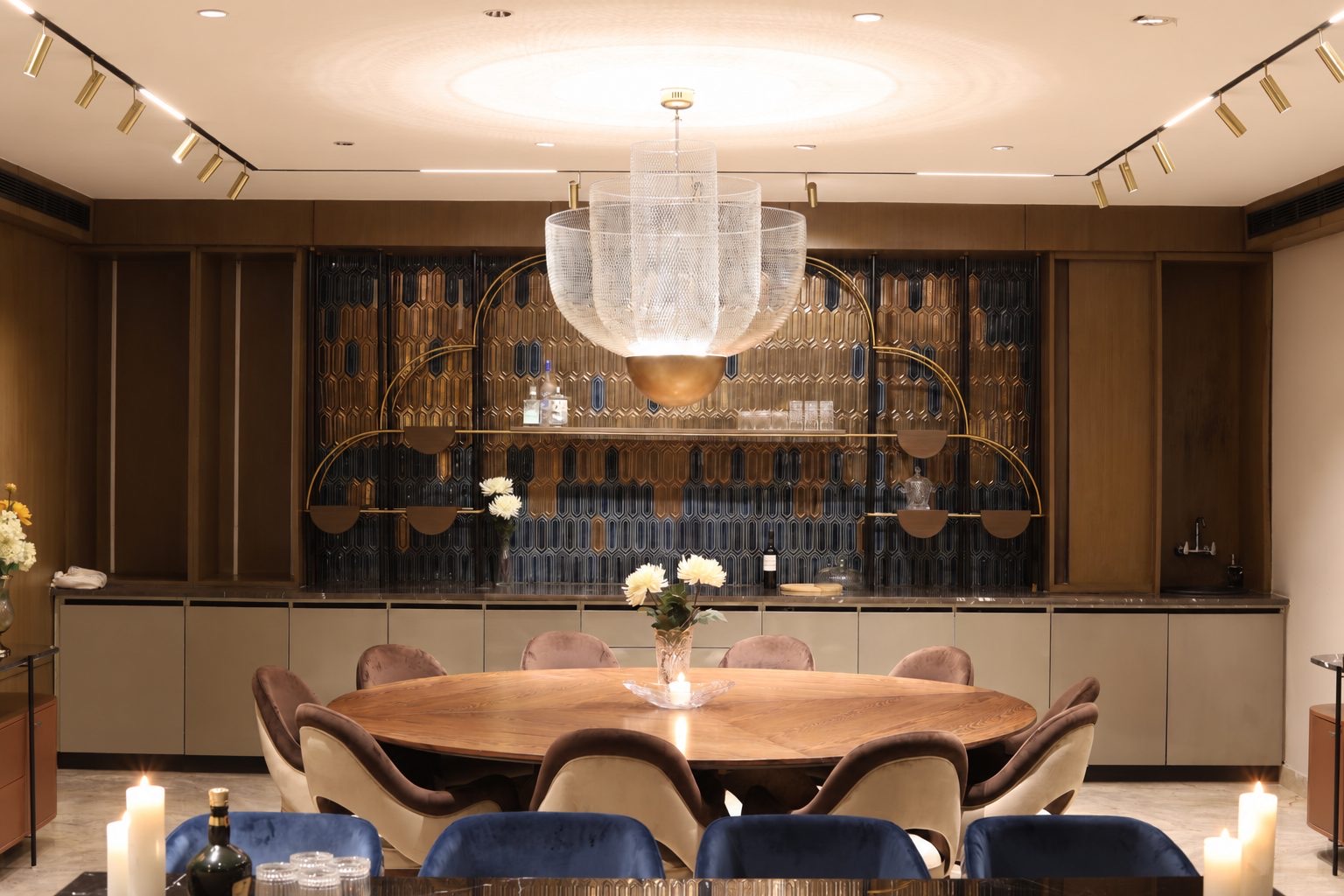 Dining room — mesh chandelier, round oak table and the glazed-tile bar wall