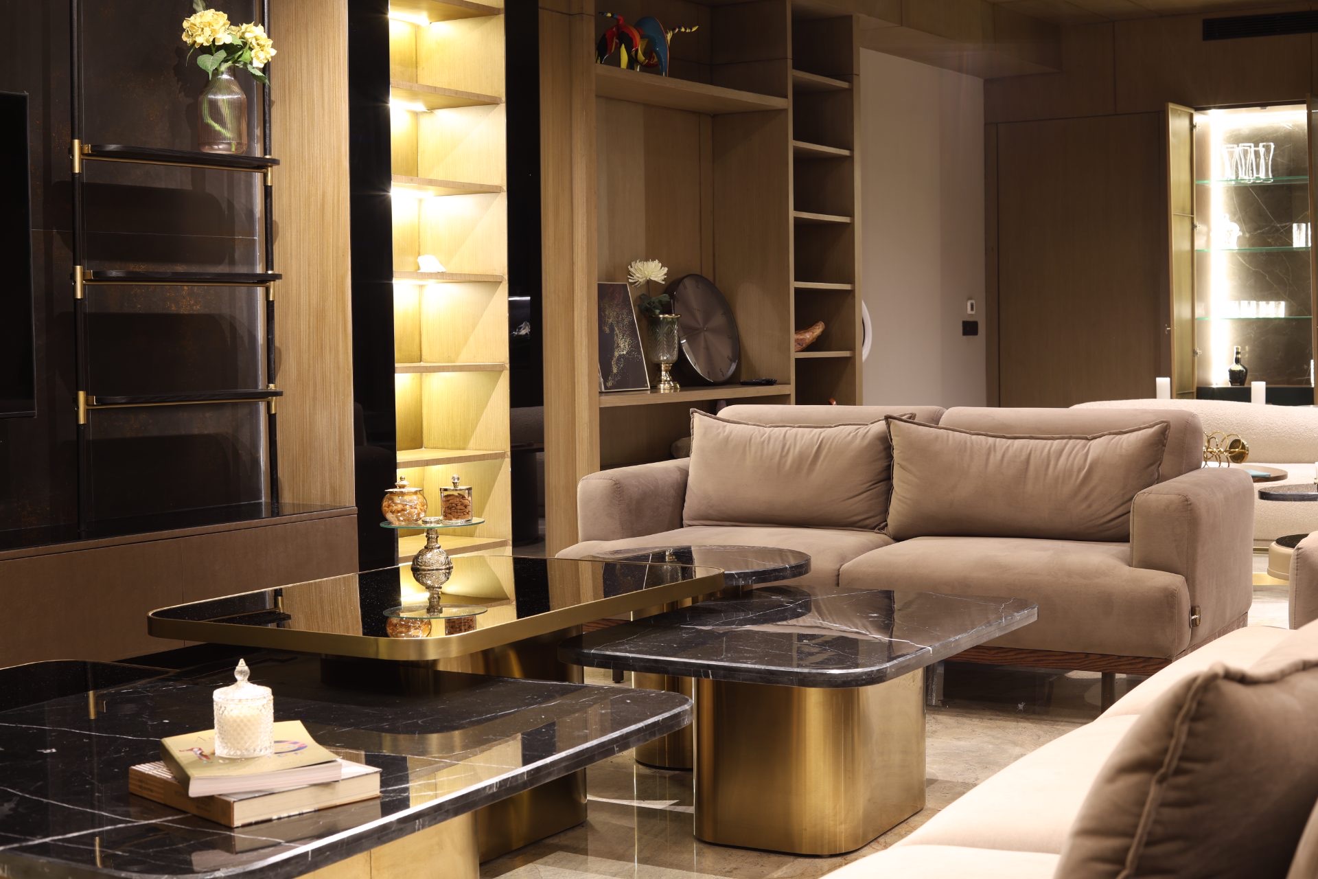 Living room — brass-edged black marble tables, oak niches and velvet sofa